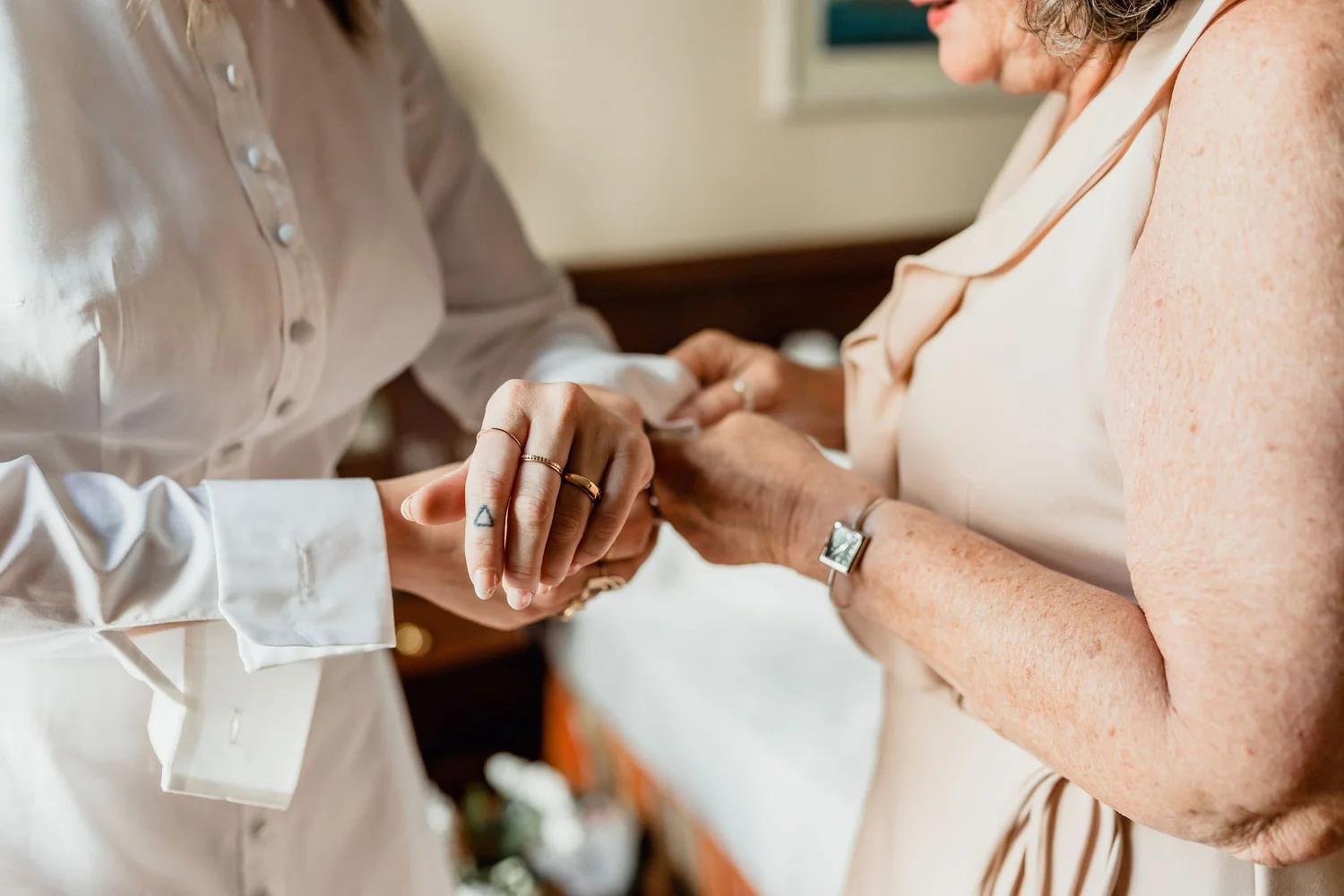 Close-up of a woman with freckles shaking hands with another woman in a professional setting.