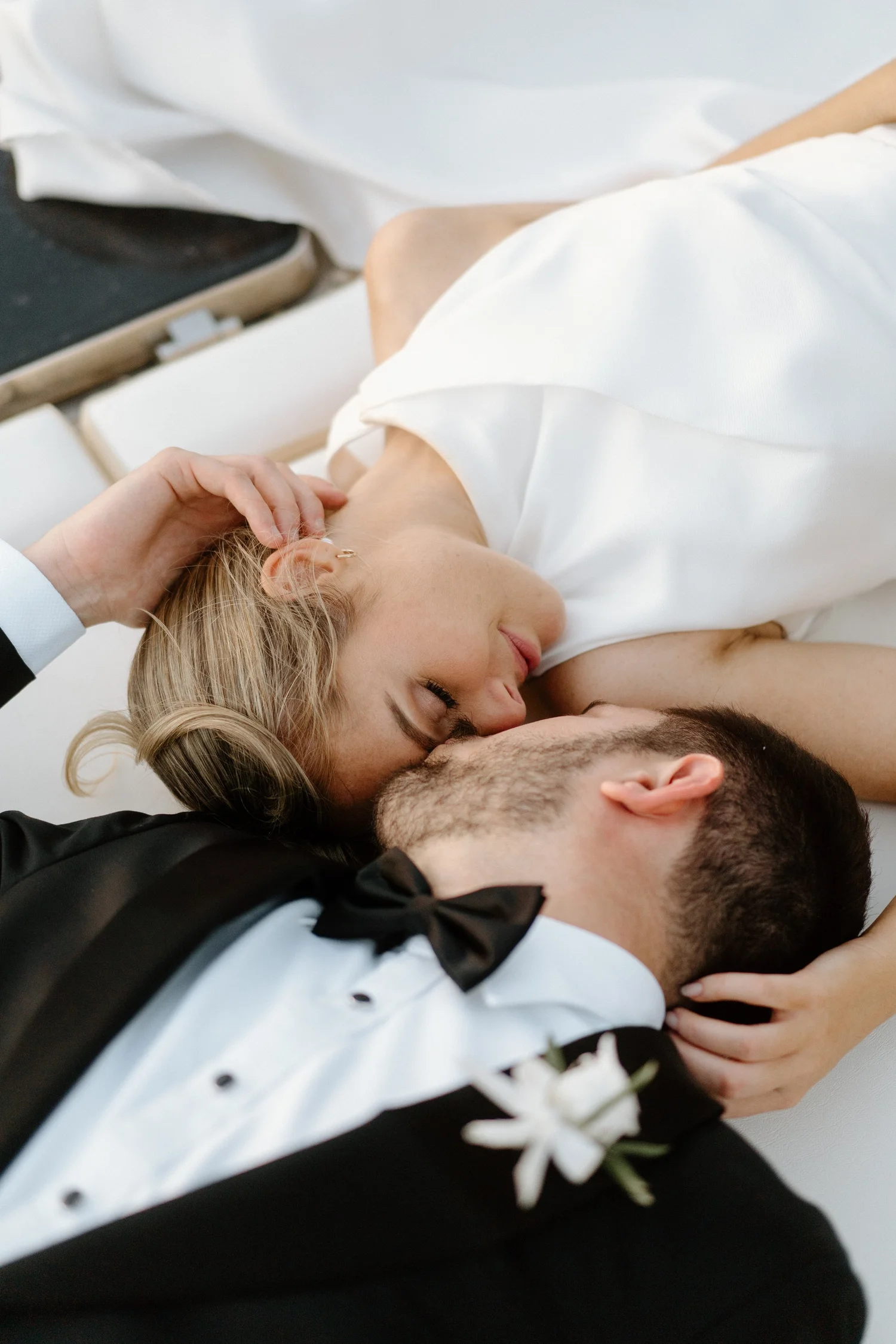 A couple lying in bed, embracing and kissing each other.