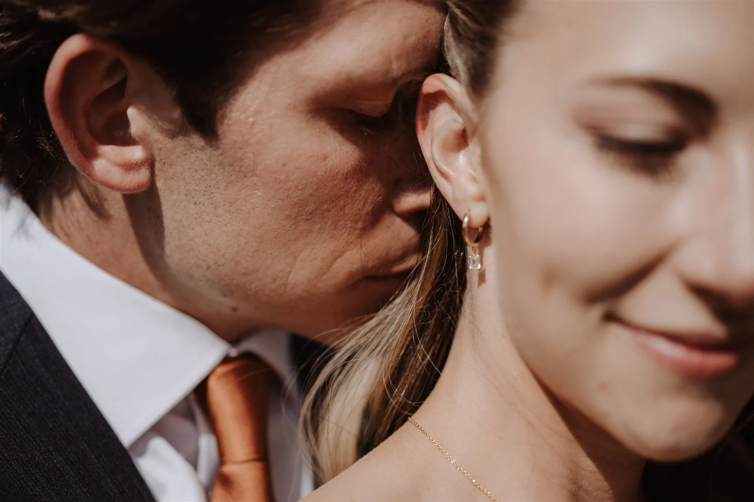 Close-up of a couple in a romantic moment, with the man's face close to the woman's face, showing their profile and expressions of intimacy.
