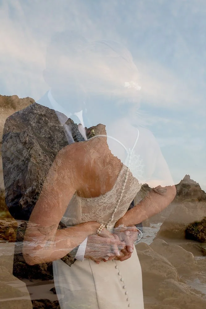 A person with a layered double exposure effect, combining a portrait of a woman with a rocky beach landscape with waves and sky.