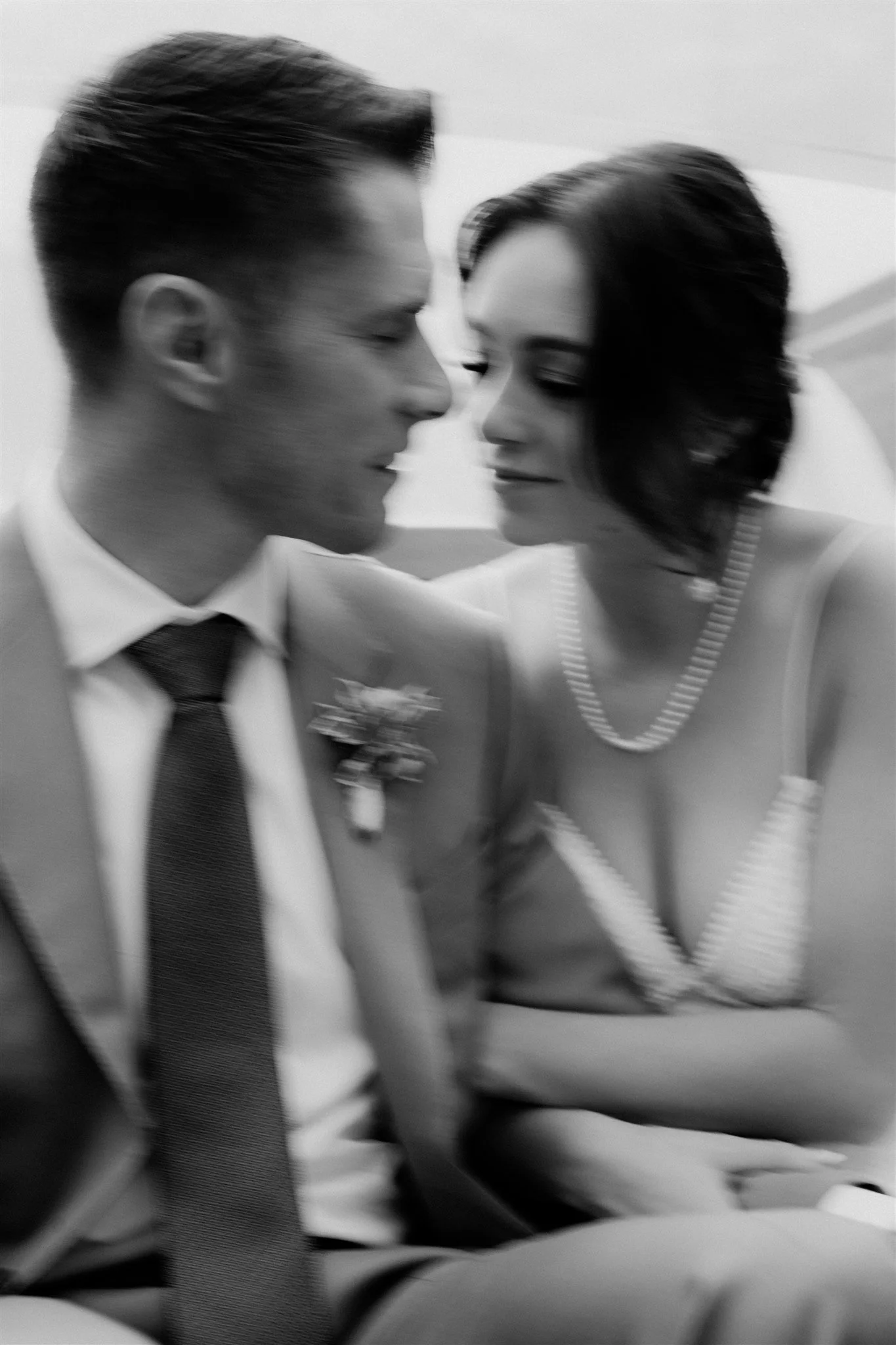 A black and white photo of a man and woman close to each other, face to face, with their eyes closed, appearing intimate and tender.